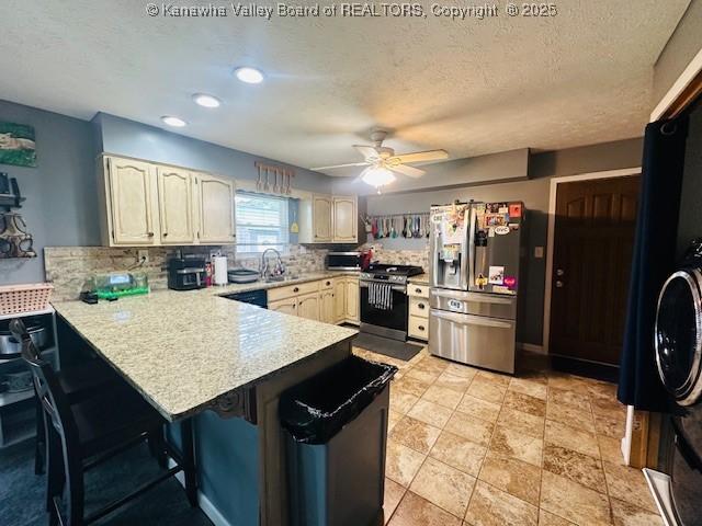 136 Timberlake Cir, Scott Depot, WV 25560 - kitchen with stainless steel appliances, a peninsula, light countertops, tasteful backsplash, and a breakfast bar area