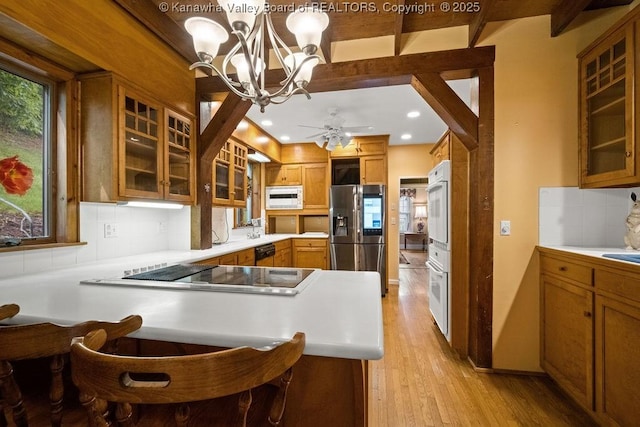 1931 Village Run Rd, White Sulphur Springs, WV 24986 - kitchen with stainless steel fridge with ice dispenser, white microwave, black electric stovetop, a chandelier, and brown cabinets