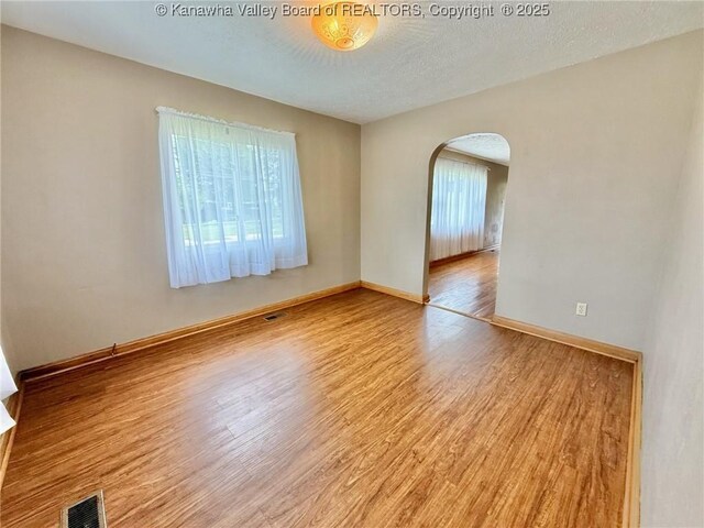 300 Sycamore St, Ravenswood, WV 26164 - empty room featuring arched walkways, wood finished floors, and baseboards