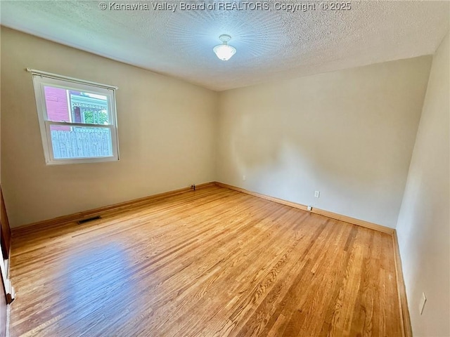 300 Sycamore St, Ravenswood, WV 26164 - spare room with wood finished floors, baseboards, and a textured ceiling