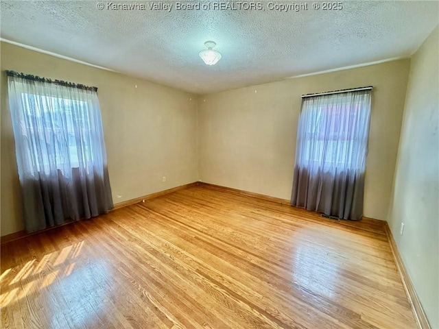 300 Sycamore St, Ravenswood, WV 26164 - spare room with plenty of natural light, wood finished floors, a textured ceiling, and baseboards