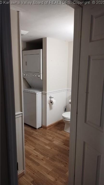 64 Haystack Ln, Charleston, WV 25311 - bathroom featuring stacked washer and clothes dryer, wood finished floors, and toilet