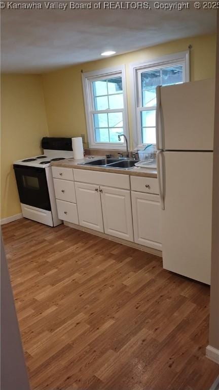 64 Haystack Ln, Charleston, WV 25311 - kitchen featuring white appliances, a sink, white cabinets, and light wood-style flooring