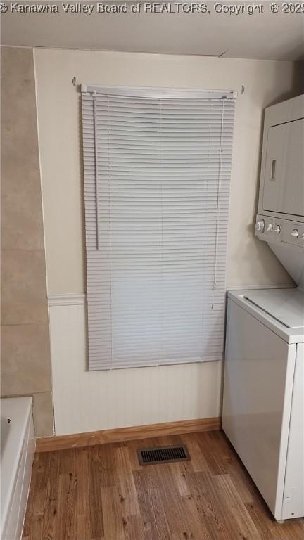 64 Haystack Ln, Charleston, WV 25311 - laundry room with estacked washer and dryer, light wood-style floors, and baseboards