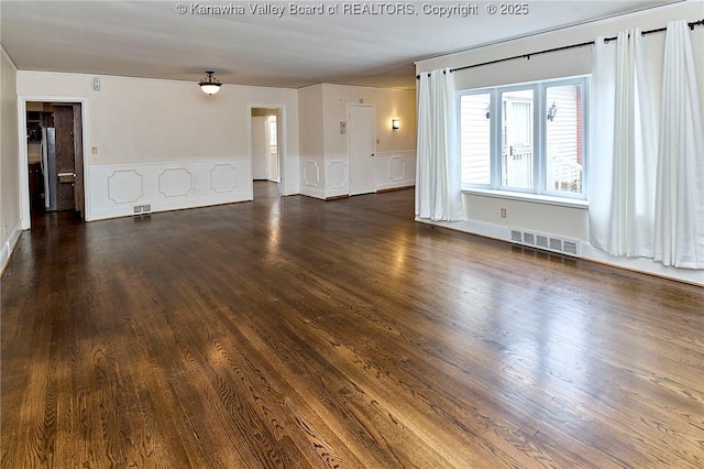 4302 Virginia Ave, Charleston, WV 25304 - unfurnished living room featuring wainscoting, a decorative wall, and dark wood finished floors