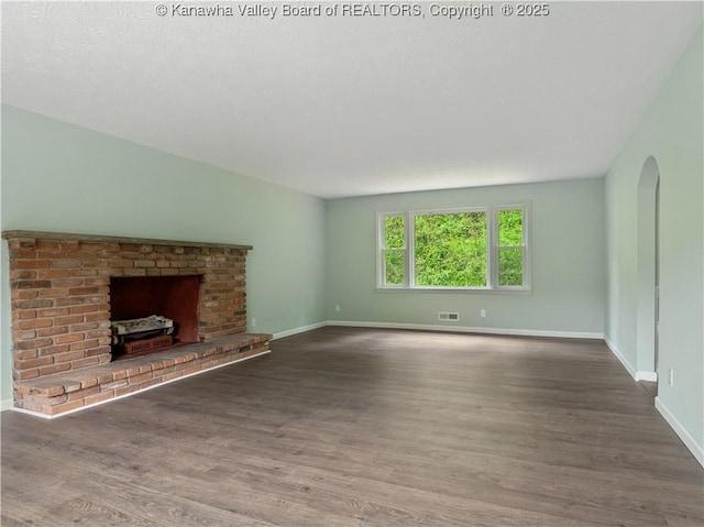 1255 Park Ave, Charleston, WV 25302 - unfurnished living room with baseboards, wood finished floors, a fireplace, and arched walkways