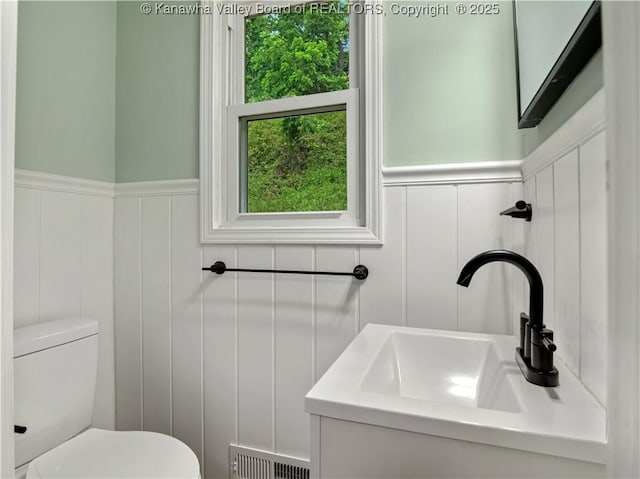 1255 Park Ave, Charleston, WV 25302 - half bath featuring a decorative wall, healthy amount of natural light, toilet, wainscoting, and vanity