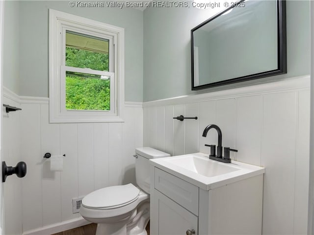 1255 Park Ave, Charleston, WV 25302 - half bath featuring a wainscoted wall, vanity, toilet, and a decorative wall