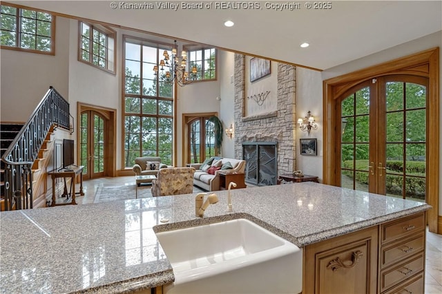 230 Quarry Rdg E, Charleston, WV 25304 - kitchen with french doors, a sink, open floor plan, a stone fireplace, and light stone counters