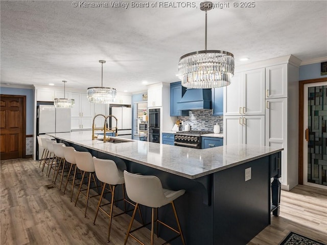 123 Brooke St, Culloden, WV 25510 - kitchen with high quality appliances, premium range hood, a chandelier, tasteful backsplash, and wood finished floors