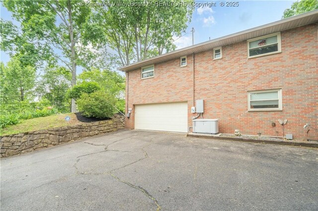 868 Alta Rd, Charleston, WV 25314 - view of home's exterior with asphalt driveway, an attached garage, and brick siding
