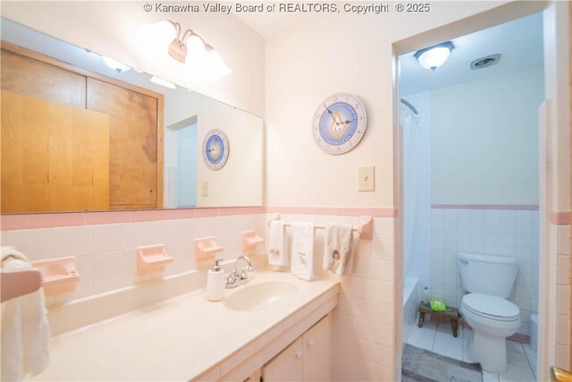 868 Alta Rd, Charleston, WV 25314 - full bath featuring vanity, toilet, wainscoting, tile walls, and tile patterned floors