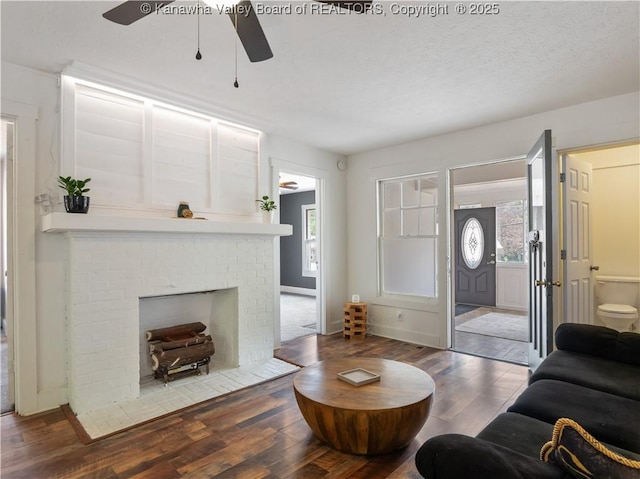 2116 21st St, Nitro, WV 25143 - living area featuring a ceiling fan, wood finished floors, a brick fireplace, and a textured ceiling
