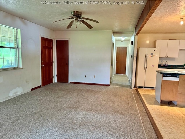 3112 Cicerone Rd, Charleston, WV 25320 - kitchen featuring freestanding refrigerator, a textured ceiling, a ceiling fan, white cabinetry, and light carpet