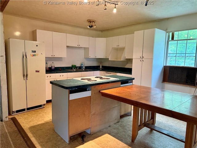 3112 Cicerone Rd, Charleston, WV 25320 - kitchen featuring white appliances, light floors, a textured ceiling, white cabinets, and a sink