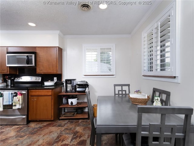 1911 Washington Ave, Saint Albans, WV 25177 - kitchen featuring stainless steel appliances, stone finish flooring, brown cabinets, backsplash, and a textured ceiling