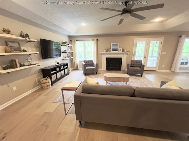 90 Brooke St, Culloden, WV 25510 - living area with a tray ceiling, light wood-style flooring, ceiling fan, a textured ceiling, and baseboards