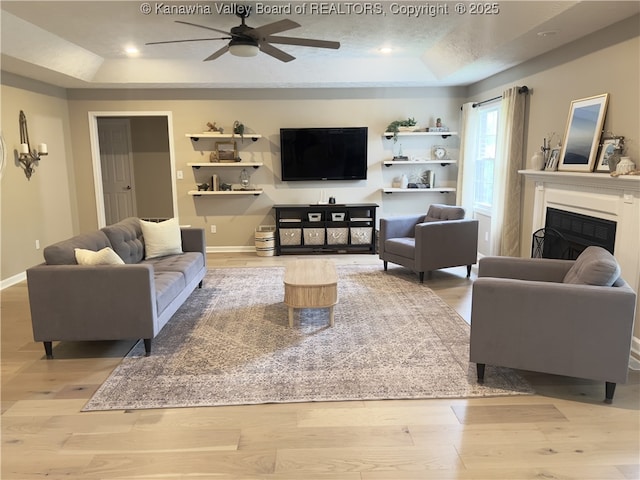 90 Brooke St, Culloden, WV 25510 - living room featuring a raised ceiling, ceiling fan, light wood finished floors, a fireplace, and baseboards