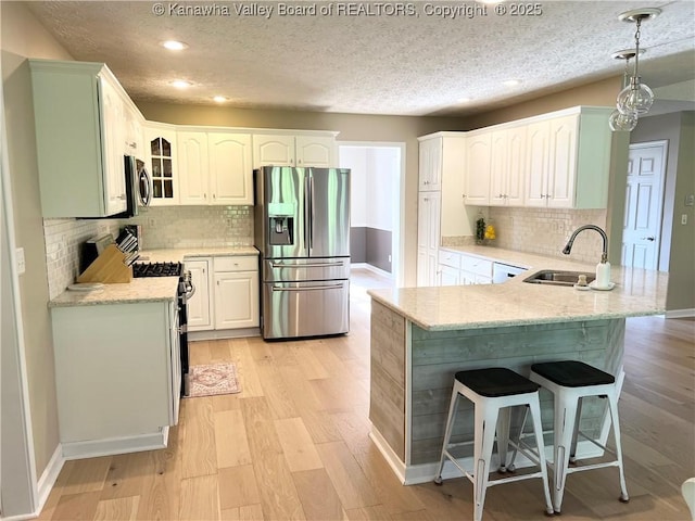 90 Brooke St, Culloden, WV 25510 - kitchen with appliances with stainless steel finishes, a sink, a peninsula, a kitchen breakfast bar, and recessed lighting