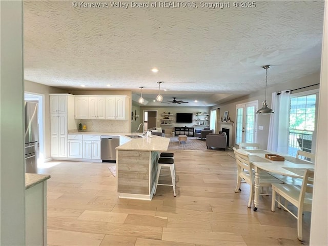 90 Brooke St, Culloden, WV 25510 - kitchen with appliances with stainless steel finishes, open floor plan, light wood finished floors, a kitchen bar, and a sink