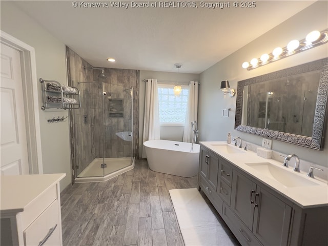 90 Brooke St, Culloden, WV 25510 - bathroom with double vanity, a shower stall, wood finished floors, a freestanding bath, and recessed lighting