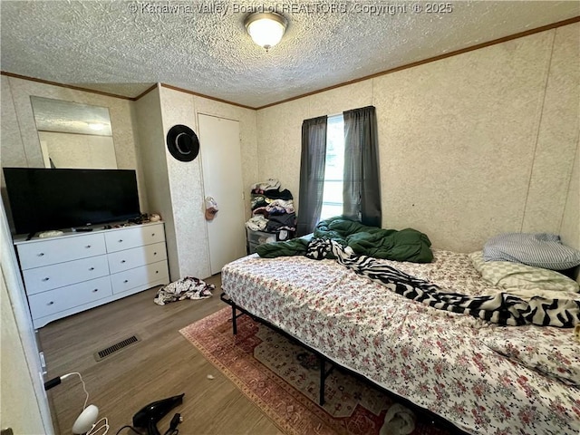 80 Restful Haven Dr, Logan, WV 25601 - bedroom featuring wood finished floors, crown molding, a textured ceiling, and a textured wall