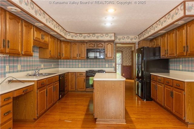 112 Willowood Cir, Hurricane, WV 25526 - kitchen featuring wallpapered walls, black appliances, light wood finished floors, a kitchen island, and a sink