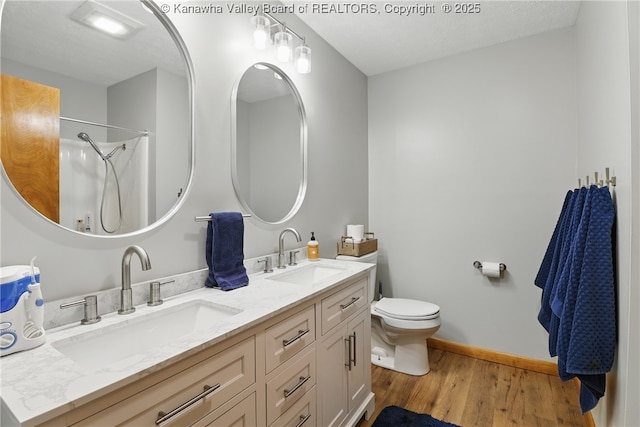 3021 Sansom Ct, Milton, WV 25541 - full bathroom with wood finished floors, double vanity, toilet, baseboards, and a shower