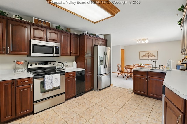3021 Sansom Ct, Milton, WV 25541 - kitchen featuring stainless steel appliances, light countertops, a sink, light colored carpet, and a peninsula
