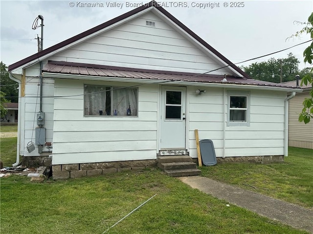 386 Maple St, Mason, WV 25260 - rear view of house featuring entry steps, metal roof, and a lawn