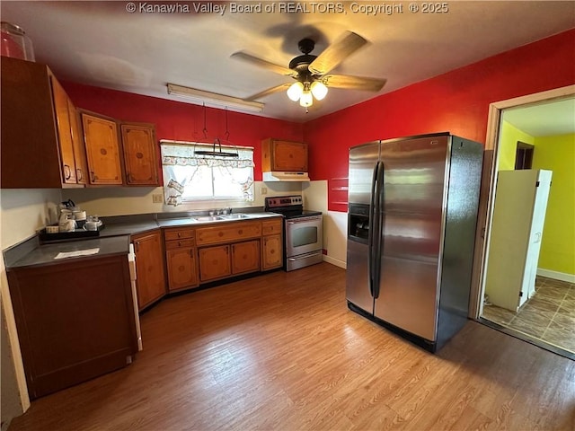 386 Maple St, Mason, WV 25260 - kitchen featuring stainless steel appliances, light wood-style floors, a sink, and brown cabinets