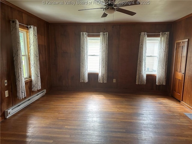 386 Maple St, Mason, WV 25260 - unfurnished room with baseboard heating, plenty of natural light, a ceiling fan, wooden walls, and wood finished floors
