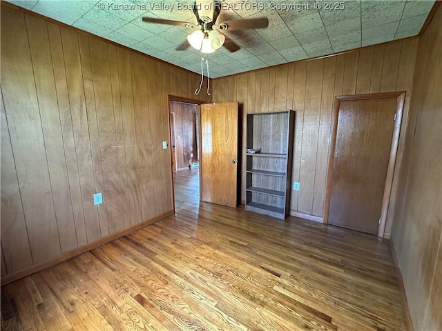 386 Maple St, Mason, WV 25260 - empty room with ceiling fan, wood finished floors, and wood walls