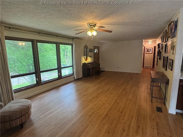 424 Porter Rd, Charleston, WV 25314 - unfurnished living room featuring a textured ceiling, wood finished floors, a ceiling fan, and baseboards