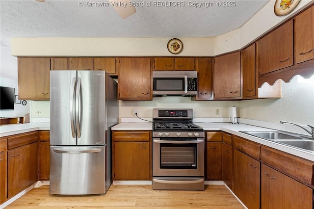 424 Porter Rd, Charleston, WV 25314 - kitchen with appliances with stainless steel finishes, a sink, light countertops, light wood-style floors, and a textured ceiling