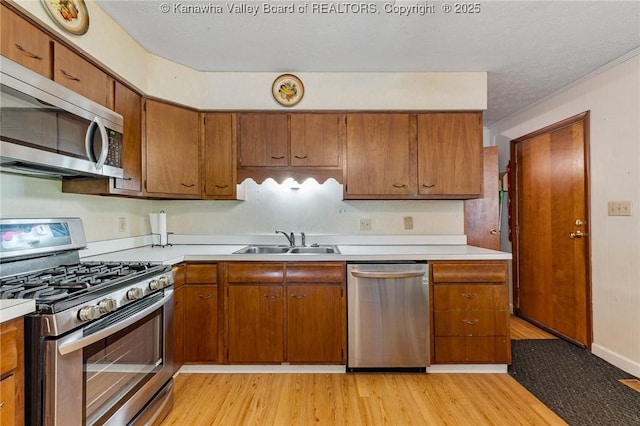 424 Porter Rd, Charleston, WV 25314 - kitchen featuring appliances with stainless steel finishes, a sink, light wood finished floors, light countertops, and a textured ceiling