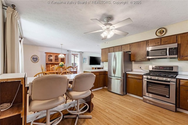 424 Porter Rd, Charleston, WV 25314 - kitchen featuring stainless steel appliances, light countertops, light wood-style flooring, ceiling fan, and a textured ceiling