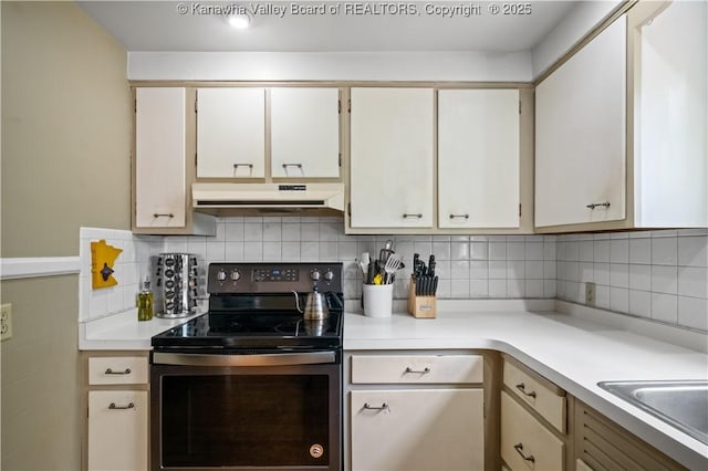 1539 Clark Rd, Charleston, WV 25314 - kitchen featuring electric stove, under cabinet range hood, light countertops, tasteful backsplash, and white cabinets