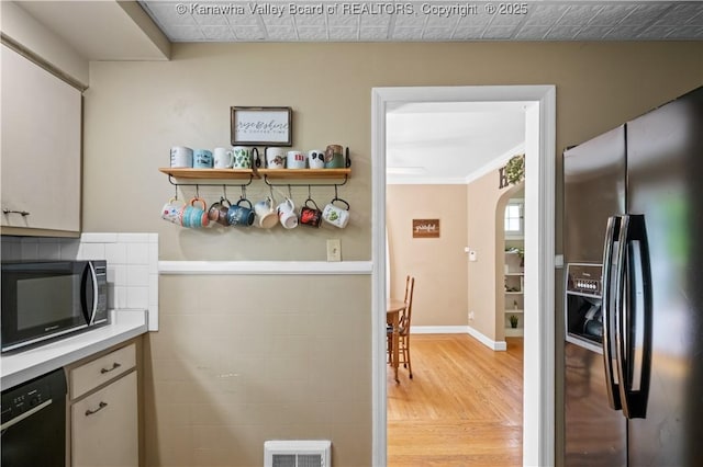 1539 Clark Rd, Charleston, WV 25314 - kitchen with black appliances, light wood-type flooring, arched walkways, light countertops, and baseboards