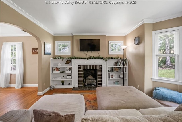 1539 Clark Rd, Charleston, WV 25314 - living room featuring arched walkways, crown molding, wood finished floors, baseboards, and a brick fireplace
