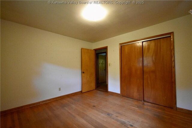 6 Coast Run Rd, Sandyville, WV 25275 - unfurnished bedroom featuring wood finished floors, baseboards, and a closet