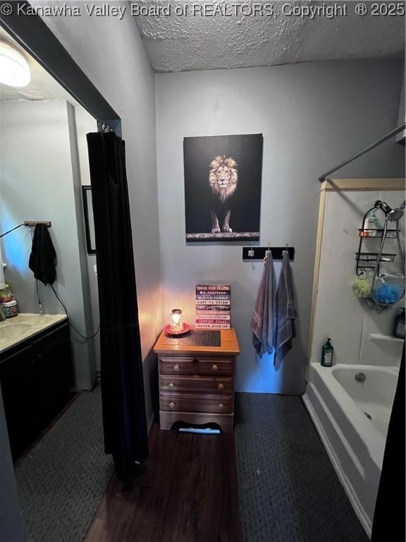 160 Davis St, Huntington, WV 25705 - bathroom with vanity, tub / shower combination, a textured ceiling, and wood finished floors