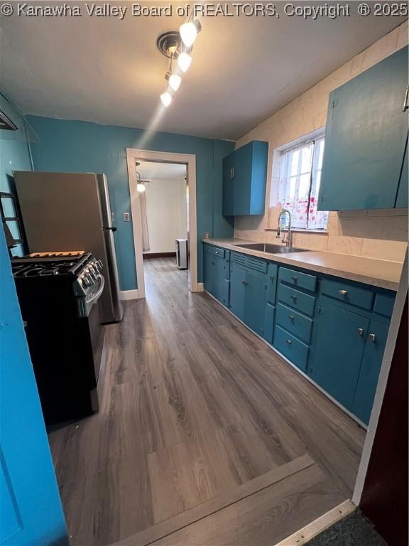 726 Amity Dr, Charleston, WV 25302 - kitchen with blue cabinets, range with gas cooktop, a sink, dark wood-style flooring, and light countertops