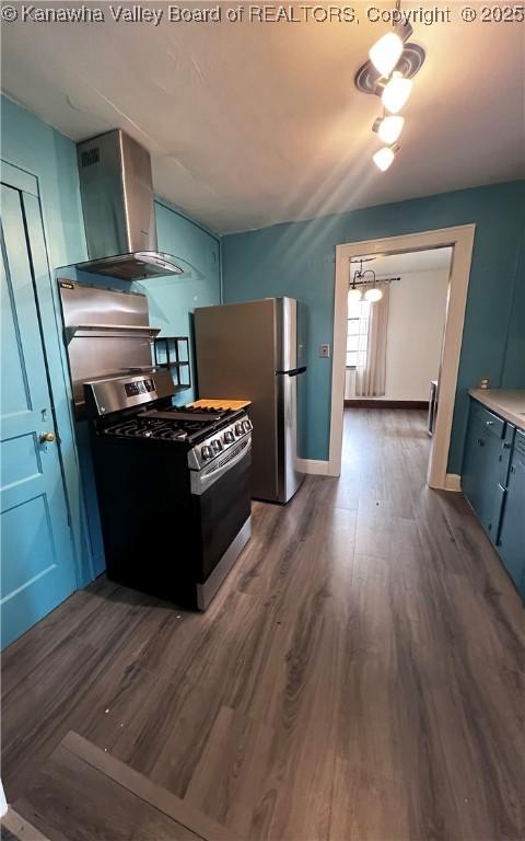 726 Amity Dr, Charleston, WV 25302 - kitchen with appliances with stainless steel finishes, wall chimney exhaust hood, blue cabinets, dark wood-style flooring, and light countertops