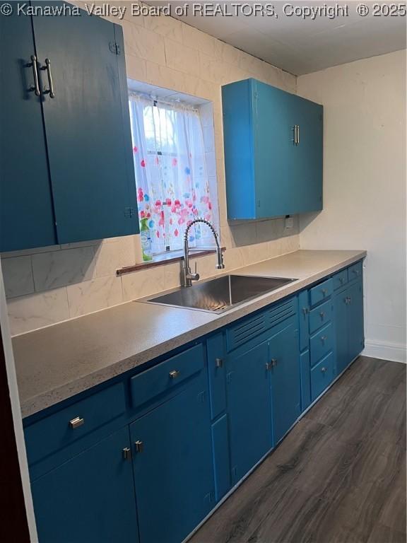 726 Amity Dr, Charleston, WV 25302 - kitchen featuring blue cabinets, a sink, dark wood-style floors, and baseboards