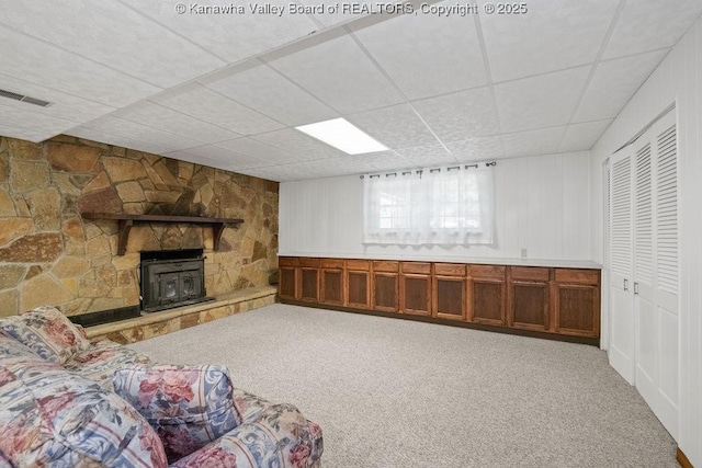 169 Burning Springs Dr, Belle, WV 25015 - unfurnished living room with carpet flooring, a drop ceiling, a wood stove, and a decorative wall