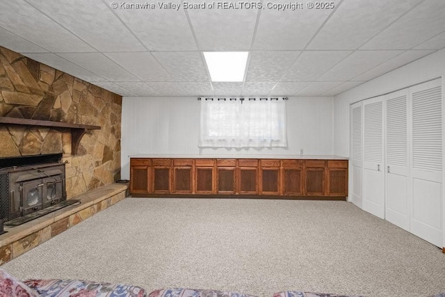 169 Burning Springs Dr, Belle, WV 25015 - basement featuring a paneled ceiling, carpet, a wood stove, and a decorative wall