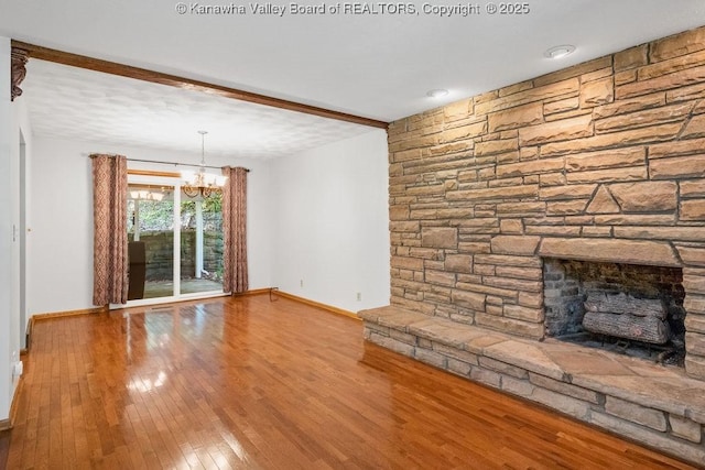 169 Burning Springs Dr, Belle, WV 25015 - unfurnished living room with baseboards, a chandelier, wood-type flooring, and a fireplace
