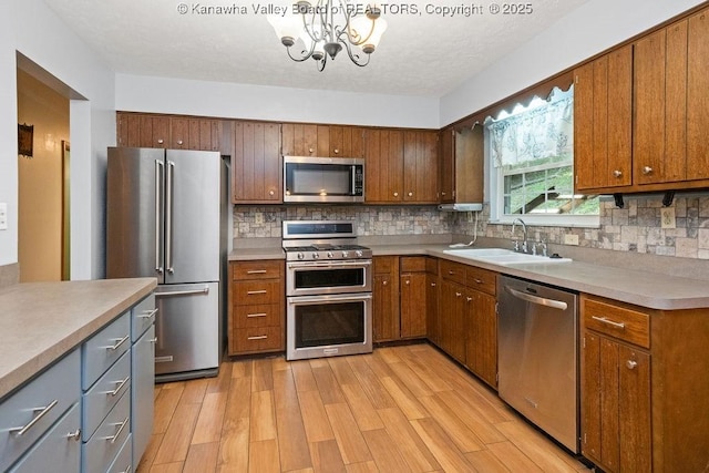 169 Burning Springs Dr, Belle, WV 25015 - kitchen with appliances with stainless steel finishes, a sink, a chandelier, tasteful backsplash, and light wood-style flooring