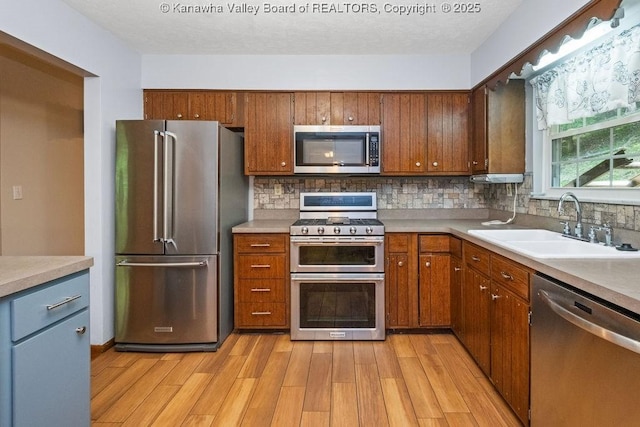 169 Burning Springs Dr, Belle, WV 25015 - kitchen featuring stainless steel appliances, a sink, light wood-type flooring, tasteful backsplash, and light countertops